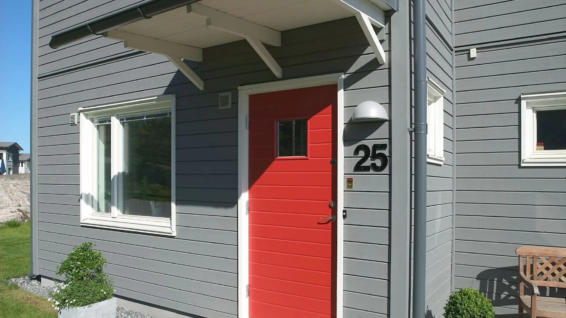 röd färg på ytterdörr till grått hus 